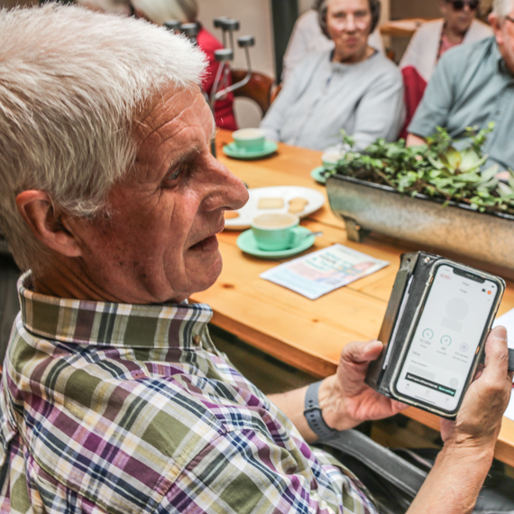 The Acorn Project - an older man using a smartphone at a DAISI event