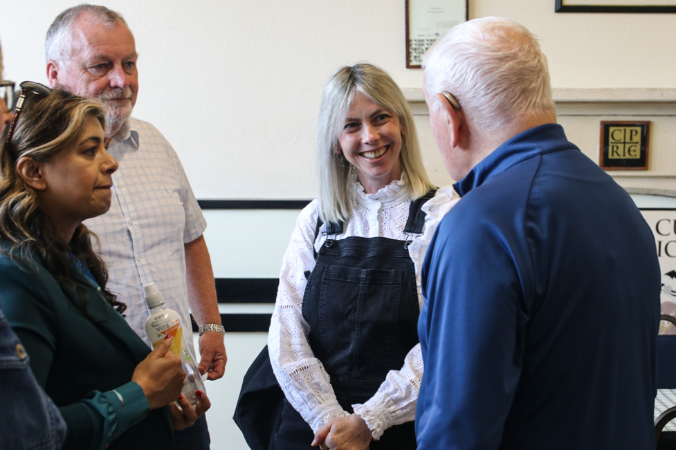Judges chat to an older resident at the community cafe in Painswick
