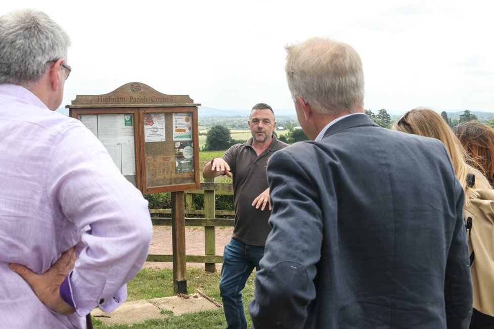 Community members and judges in Highnam next to a village notice board