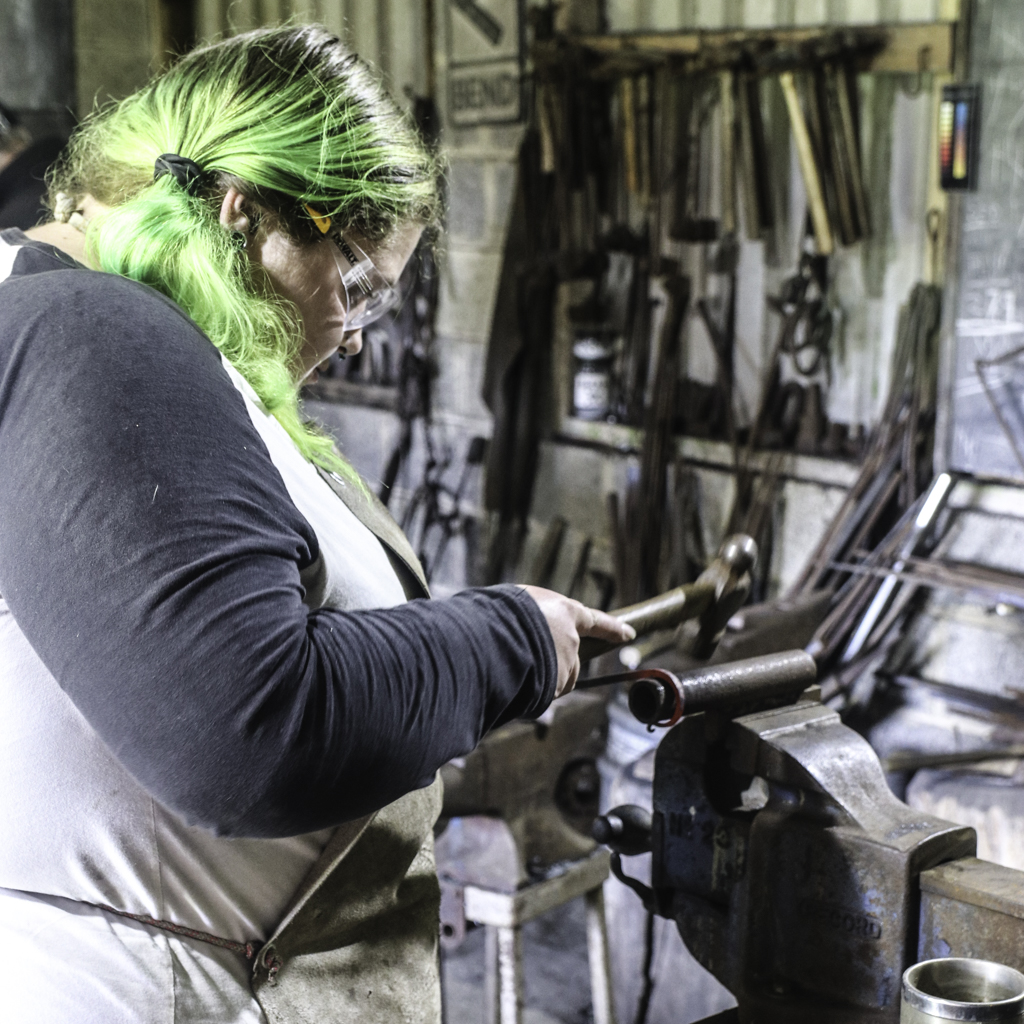 blacksmithing students working in the forge