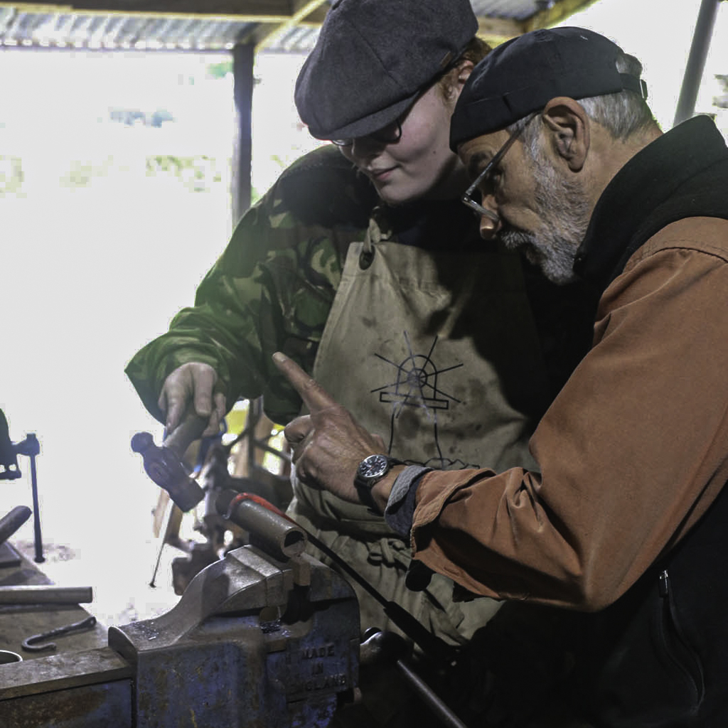 blacksmithing students working in the forge