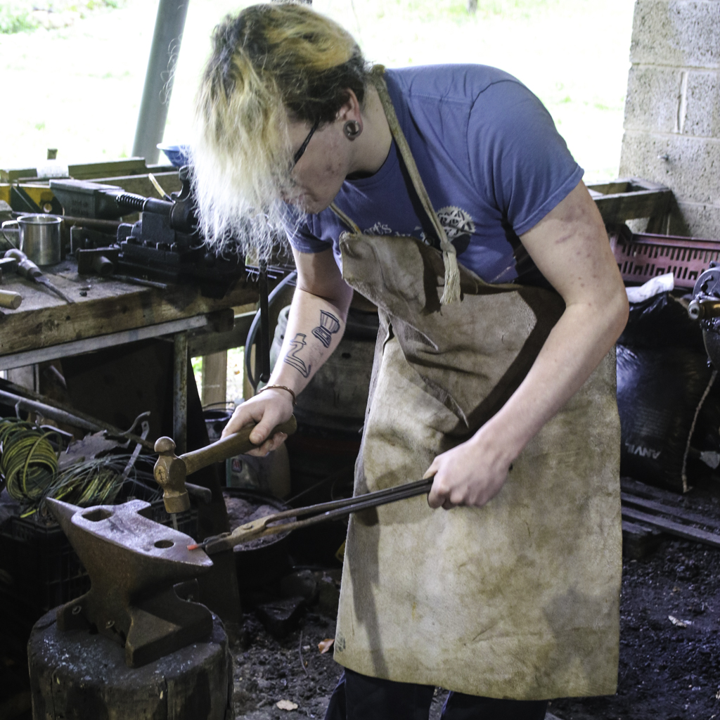 blacksmithing students working in the forge