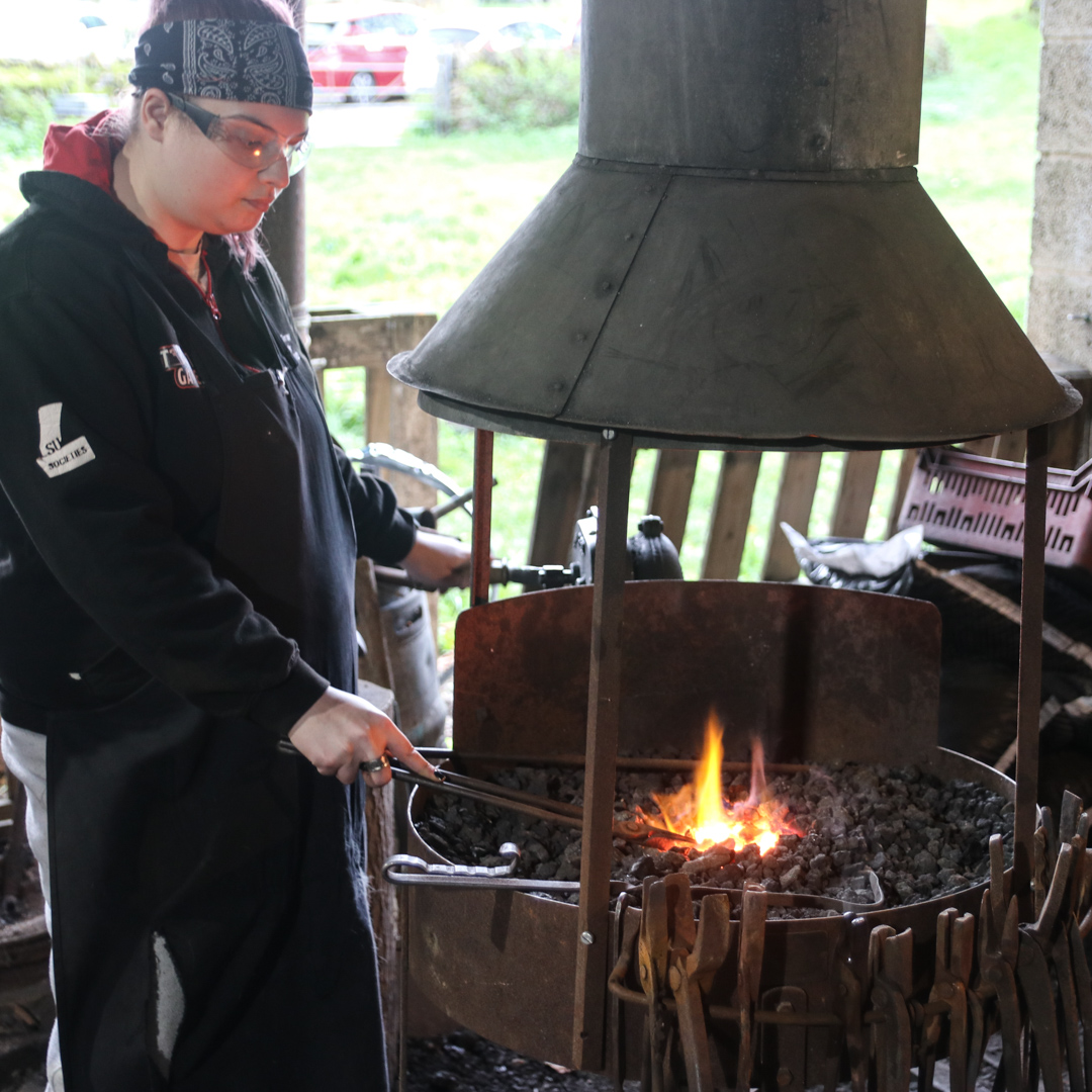 blacksmithing students working in the forge